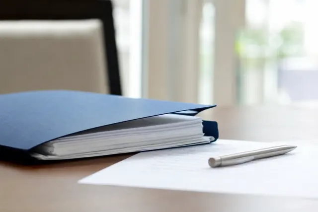 Dossier de prêt immobilier et contrat d'assurance posés sur une table avec un stylo