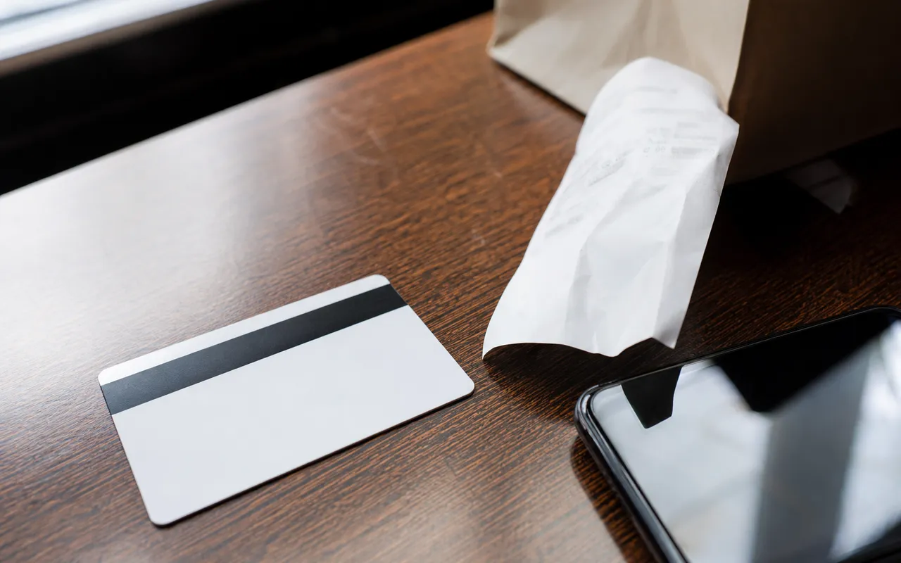 Carte cadeau posée sur une table à côté d'un reçu et d'un téléphone