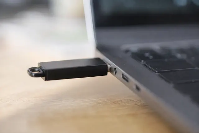 Clé USB branchée sur le port d'un ordinateur portable, gros plan