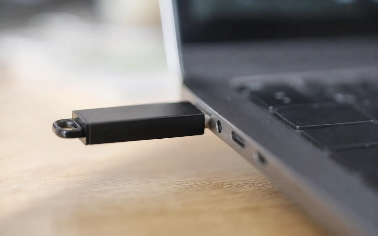 Clé USB branchée sur le port d'un ordinateur portable, gros plan