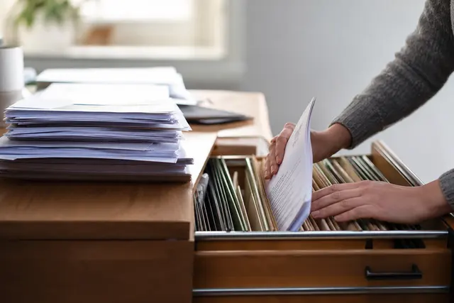 Classement de documents administratifs et factures dans des dossiers suspendus à la maison
