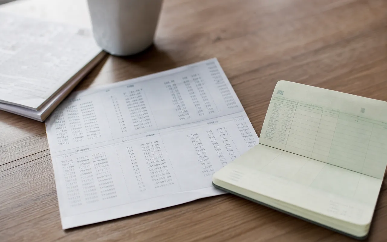 Relevé bancaire et carnet d'épargne posés sur une table