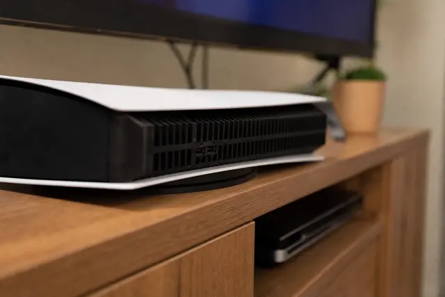 Console de jeu vidéo posée sur un meuble avec sa grille de ventilation visible