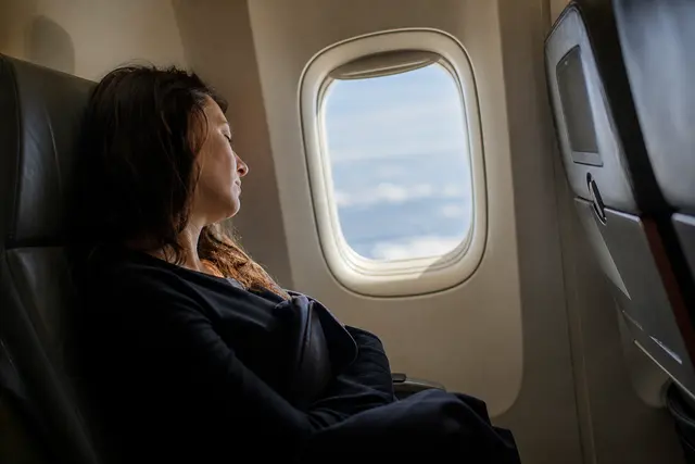 Voyageur assis près d'un hublot d'avion, lumière du jour entrant dans la cabine