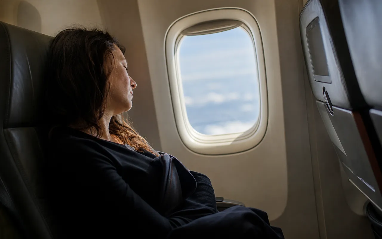 Voyageur assis près d'un hublot d'avion, lumière du jour entrant dans la cabine