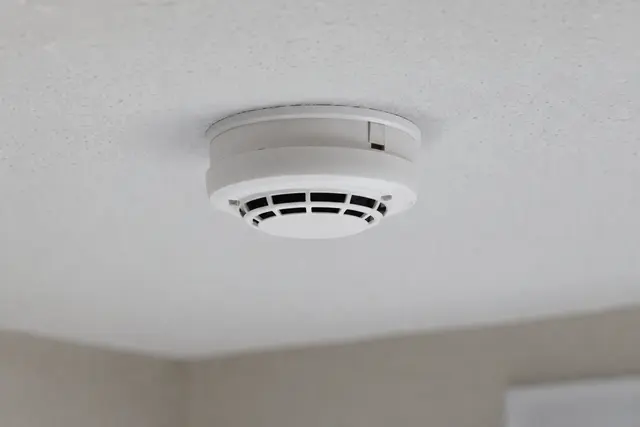 Détecteur de fumée blanc fixé au plafond d'une pièce