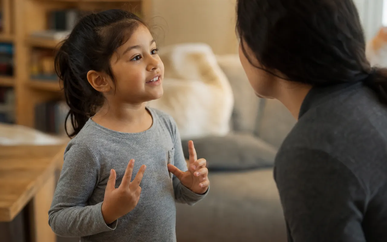 Enfant en train de parler et de jouer avec un adulte, moment de complicité