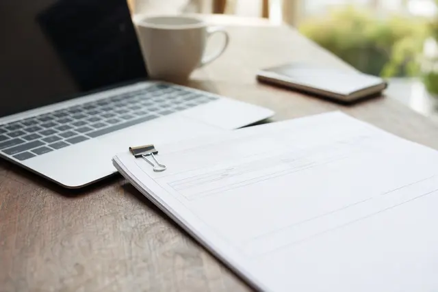 Facture professionnelle posée sur un bureau à côté d'un ordinateur portable