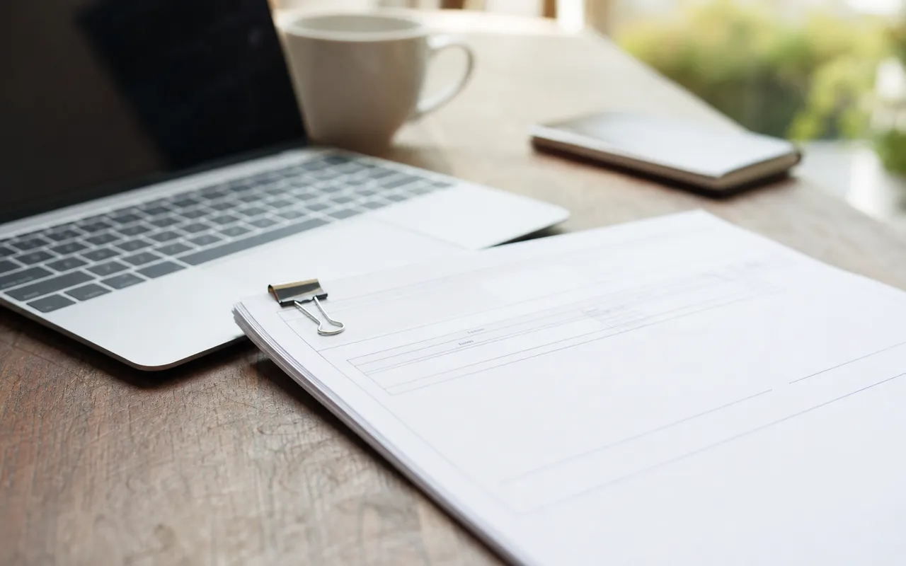 Facture professionnelle posée sur un bureau à côté d'un ordinateur portable