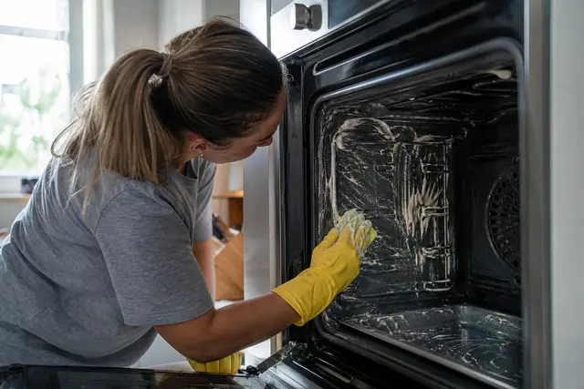 Intérieur d'un four électrique propre après nettoyage, porte ouverte dans une cuisine lumineuse