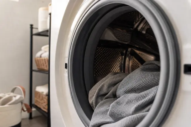 Intérieur d'un tambour de lave-linge ouvert avec le joint en caoutchouc du hublot visible