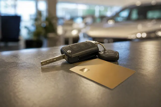 Clés de voiture de location posées sur un comptoir avec une carte bancaire à proximité
