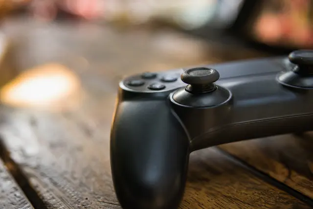 Manette de jeu vidéo posée sur une table, gros plan sur un joystick analogique