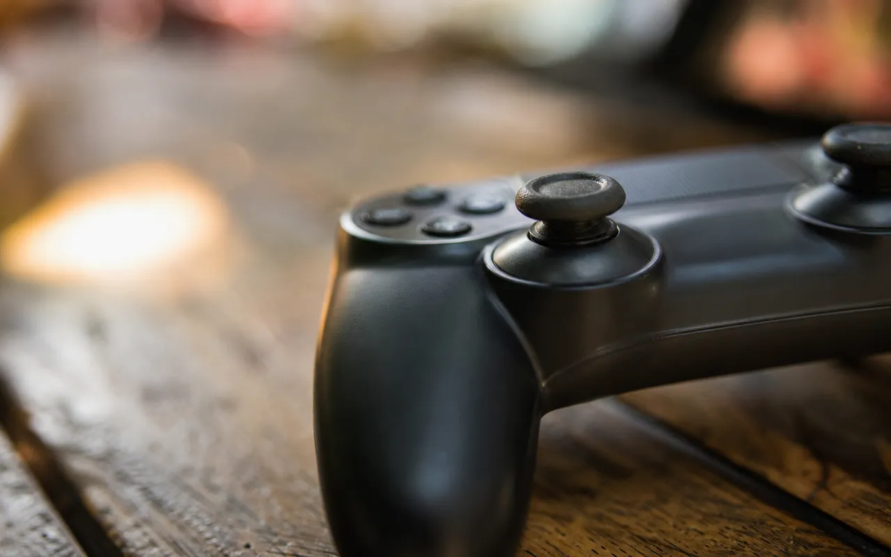 Manette de jeu vidéo posée sur une table, gros plan sur un joystick analogique