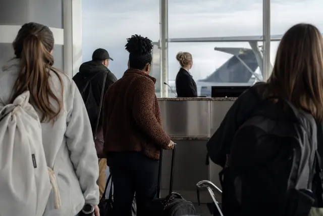 Passagers attendant devant un comptoir d'embarquement dans un aéroport