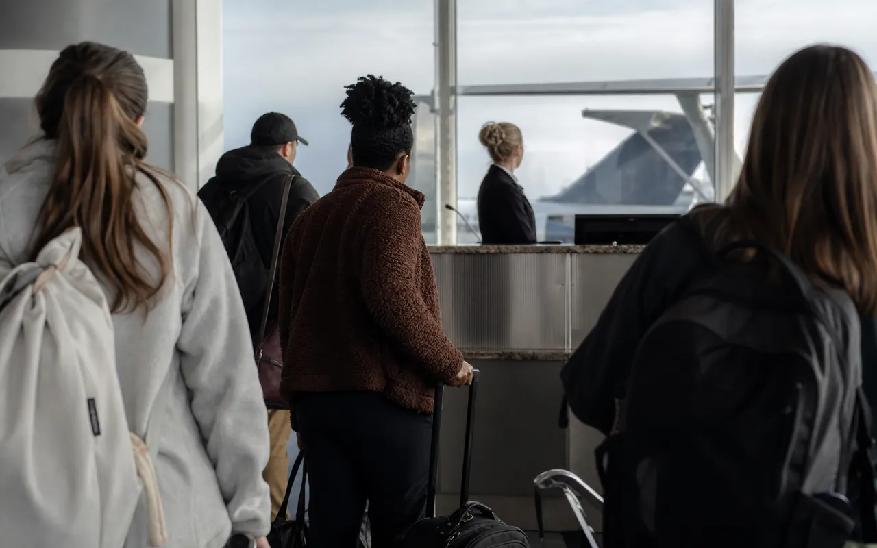 Passagers attendant devant un comptoir d'embarquement dans un aéroport