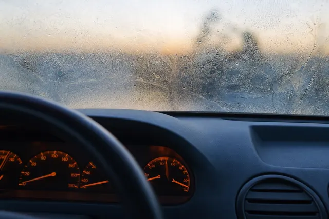 Intérieur d'un habitacle de voiture avec le tableau de bord allumé par un matin froid
